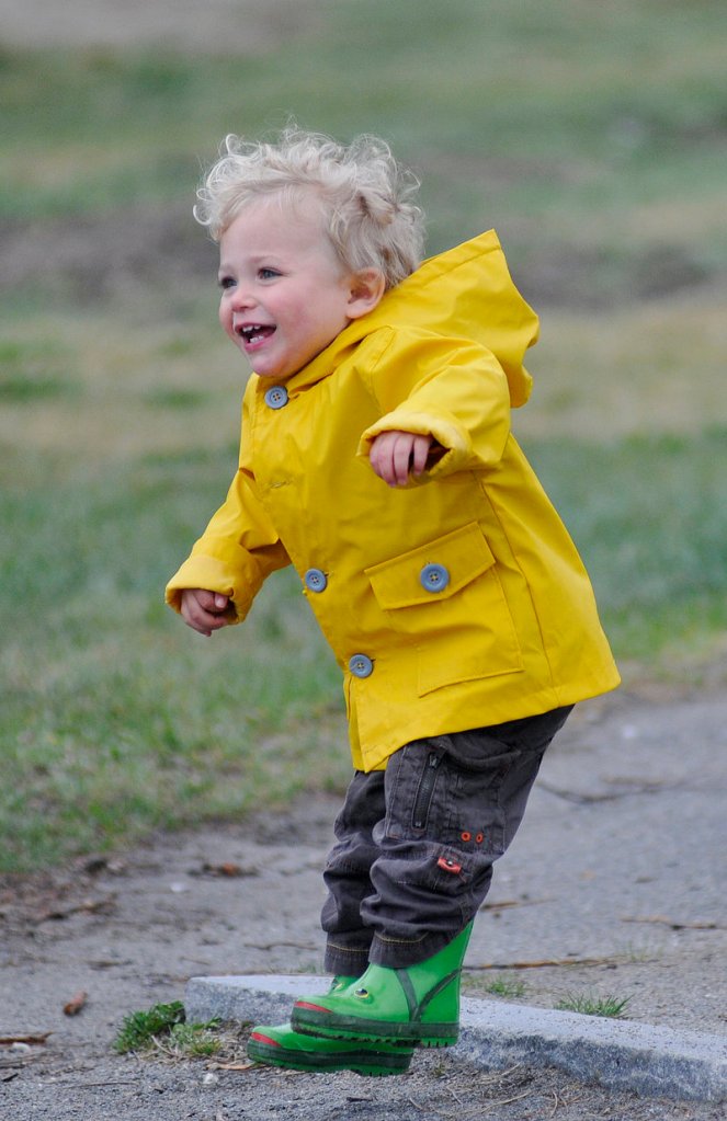 Jasper Forgit, 1, of Portland jumps with his raincoat and boots on as he walks with his grandmother, Mary Ann Forgit, near East End Beach in Portland on Sunday.