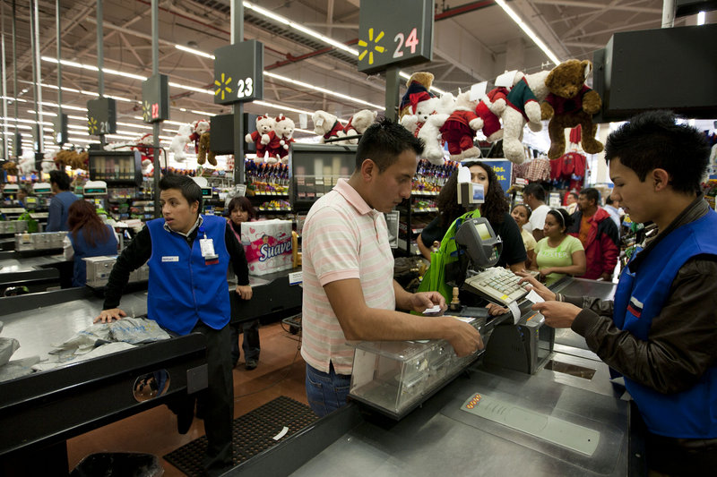 A man pays at the cash register at a Walmart Superstore in Mexico City. Walmart Stores Inc. hushed up a vast bribery campaign that top executives of its Mexican subsidiary carried out to build stores across Mexico, according to The New York Times.