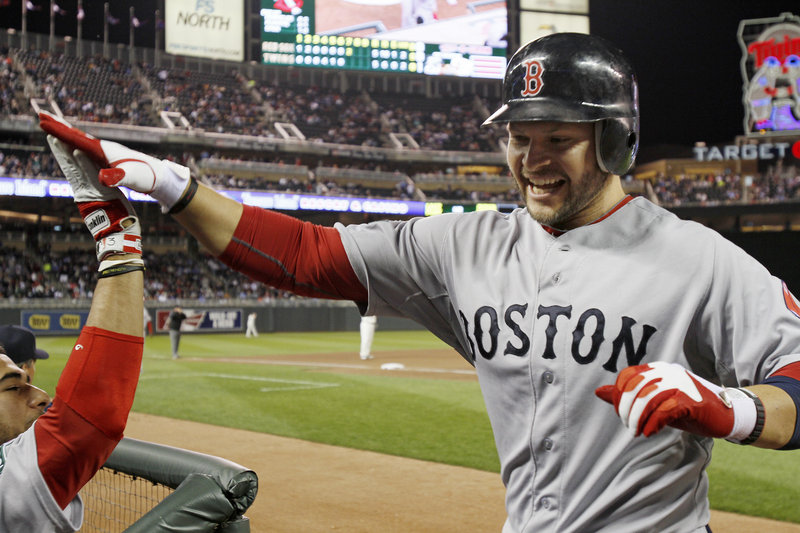 Cody Ross returns to the dugout after tying the game with a two-run homer in the seventh inning Monday. Ross also homered in the ninth to give the Red Sox a 6-5 win.