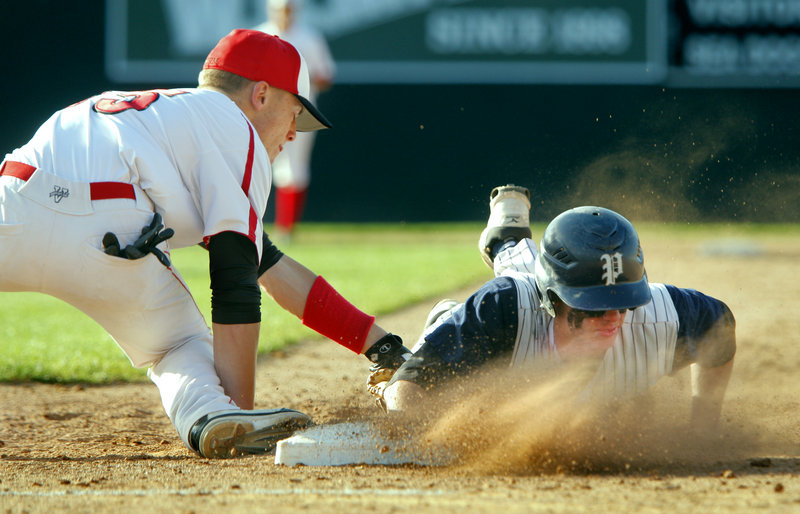 Nick Volger of Portland gets a face full of dirt Tuesday while making it back to first base ahead of a tag by Sam Wessel of Scarborough during their game at Hadlock Field. Scarborough came away with a 5-3 victory.