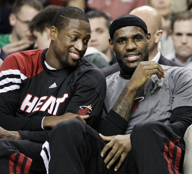 Dwyane Wade, left, and LeBron James spent the evening chatting on the bench Tuesday, spectators in a game neither team took seriously. Scoreboard said Celtics beat Miami.