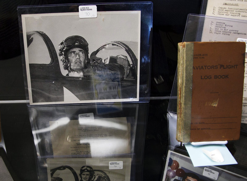 A Korean War-era photograph of Ted Williams sits in a display case next to a 1952-1953 flight log book during the auction preview Wednesday at Fenway Park. Fans will be able to see hundreds of items during the preview, which will last through Friday. The auction is Saturday.