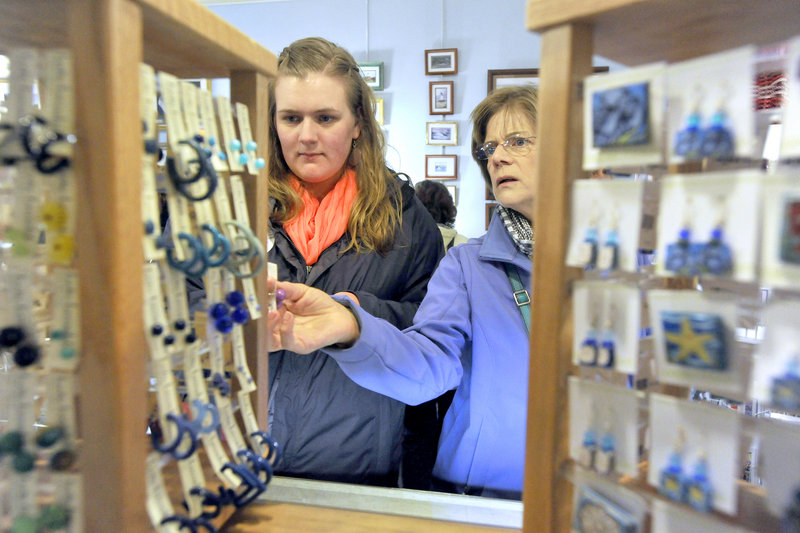Cash mob participants Katie Lybrand, left, and her mom, Karen, look over some earrings at Lisa-Marie’s Made in Maine, a shop on Exchange Street in Portland, on Thursday evening. The social-media-driven cash-mob events are designed to promote patronage at local businesses.