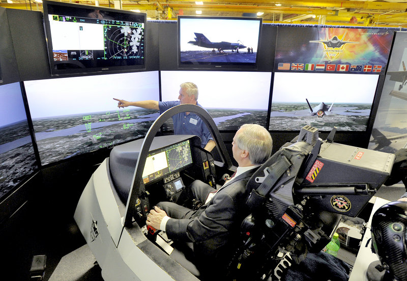 Maine’s senior economic adviser John Butera gets flight instruction Friday from Tony Stutts at Lockheed Martin’s demonstration of an F-35 fighter jet in a simulator at Pratt & Whitney in North Berwick. Lockheed Martin is building the jets that will use engines manufactured at the Maine plant.