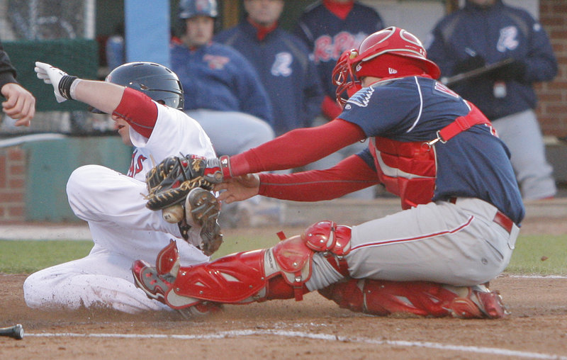 Bryce Brentz, left, of the Sea Dogs scores one of his two runs as Reading catcher Sebastian Valle drops the ball during the fourth inning Friday night in Portland.