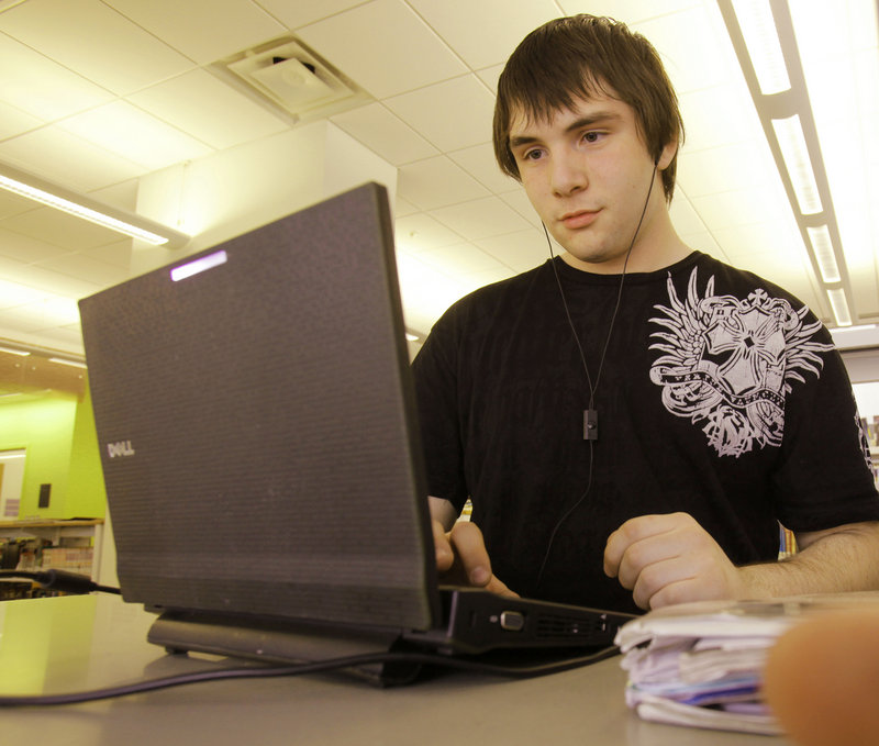 Sean Bouchard, a senior at Portland High School, uses his school-issued netbook computer at the Portland Public Library. New restrictions will block access to social media and video streaming sites for users of the school equipment.