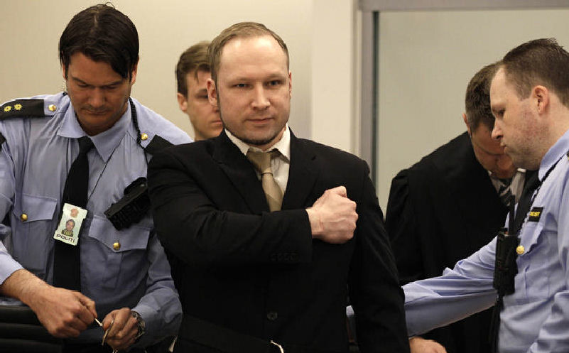 Anders Behring Breivik, center, gestures as he arrives at the courtroom Monday in Oslo, Norway.