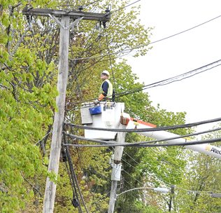 A CMP crew works to repair a utility pole that was struck and split by a truck along Cumberland Street in Westbrook near Brown Street. Police blocked off that section to traffic as repairs continued.