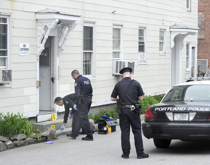 Portland police officers investigate the scene of a stabbing earlier today at 9 Cedar St. in Portland.