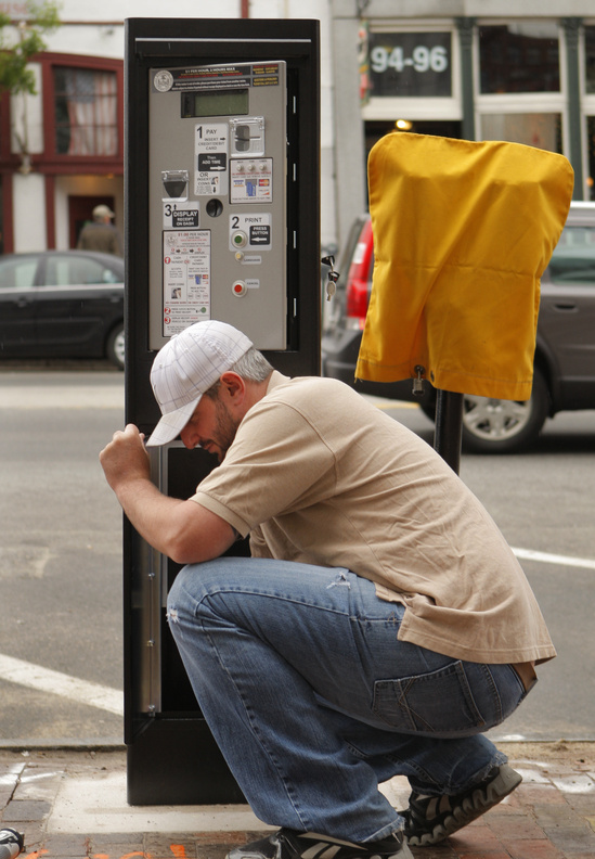 Dan Culliton sets up a solar-powered parking station on Commercial Street in Portland on Monday, one of 18 the city is installing. The stations, which go on line next Monday, produce tickets, below, that must be displayed on cars’ dashboards.