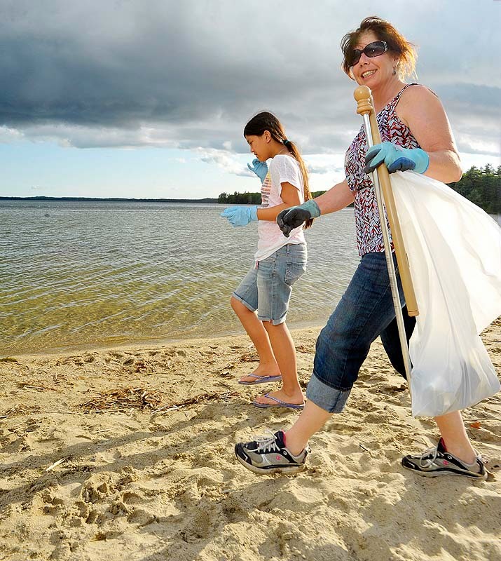 Gordon Chibroski / Staff Photographer. WEDNESDAY, May 23, 2012. New Raymond Beach Manager Joanne Alfiero walks the beach near sunset with her daughter, Grace, 11, picking up trash; something they plan on doing daily.