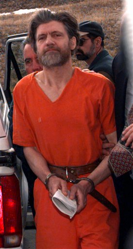 FILE - In this April 4, 1996 file photo, Ted Kaczynski, also known as the Unabomber, is escorted into the federal courthouse in Helena, Mont. Harvard alumni attending their 50th class reunion are getting updates on classmates _ including Kaczynski, who graduated in 1962. In an alumni directory, he lists his occupation as �prisoner� and under awards lists �eight life sentences.�(AP Photo/Elaine Thompson, File)