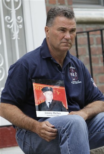 Retired firefighter Jim Riches poses for a picture with a photography of his son near his home in New York, Thursday, May 3, 2012. Riches, whose son was killed during the 2001 terrorist attacks on the World Trade center, will be among those to watch the arraignment of Khalid Sheikh Mohammed. The arraignment of the self-proclaimed mastermind of the Sept. 11 terror attacks and four other Guantanamo Bay prisoners will be broadcast to only six sites at four military bases in the U.S. Northeast, a Pentagon spokesman said Monday. (AP Photo/Seth Wenig)