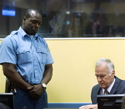 Former Bosnian Serb military commander Gen. Ratko Mladic, right, and a UN security guard are seen at the start of his trial at the Yugoslav war crimes tribunal in The Hague, Netherlands, today.