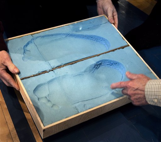 Shoe engineers examine foot imprints from Igor Vovkovinskiy, of Minneapolis, at Reebok headquarters today.