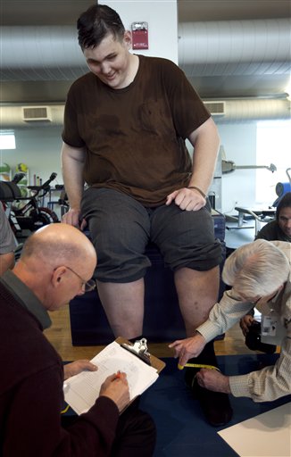 Igor Vovkovinskiy, of Minneapolis, currently the tallest man in the United States, has his feet measured by shoe technicians as part of a shoe fitting at Reebok headquarters in Canton, Mass., today.