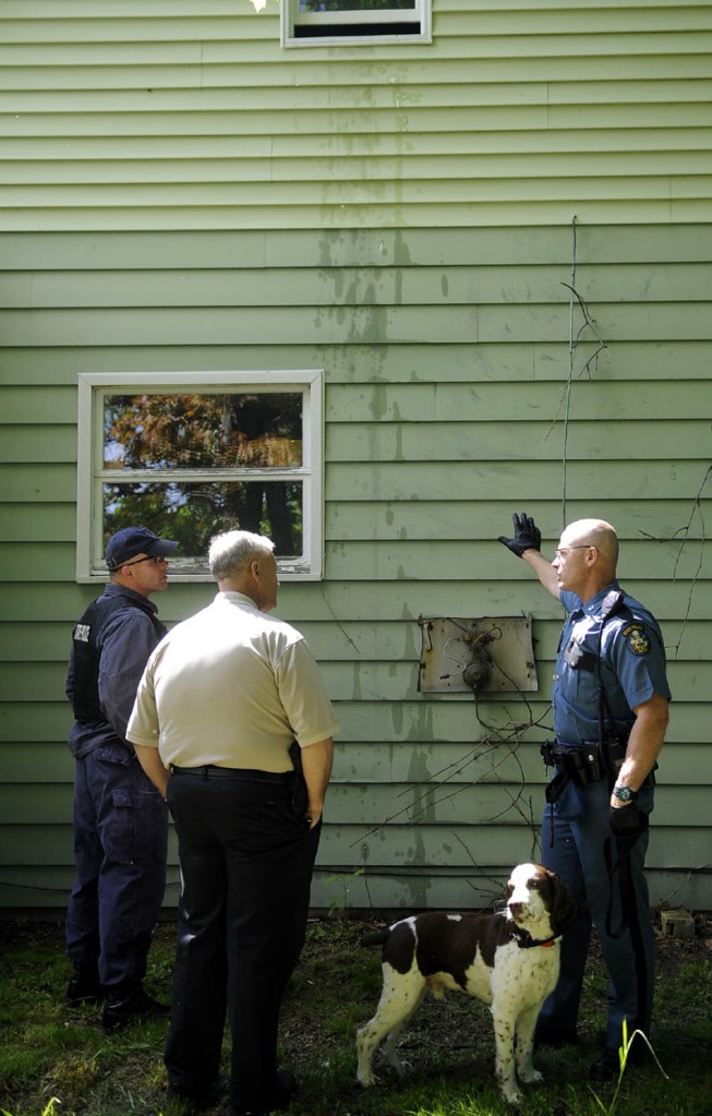 Maine State Police officer Robert Cejka, right, confers with Augusta Police Lt. Keith Brann, center, and State Police Sgt. Jeff Mills Thursday outside an apartment building that Cejka searched with his bomb sniffing dog on Gage Street in Augusta. Law enforcement officers from several agencies searched two apartment buildings on the street for explosive materials.