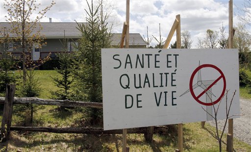 A Stanstead, Quebec, resident posts a sign opposing a Vermont wind development.