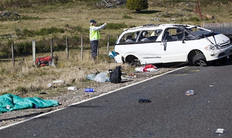 Policemen examine the scene of a minivan crash near Turangi, New Zealand, Saturday, May 12, 2012. Three Boston University students who were studying in New Zealand were killed Saturday when their minivan crashed. At least five other students from the university were injured in the accident, including one who was in critical condition. (AP Photo/New Zealand Herald, John Cowpland)