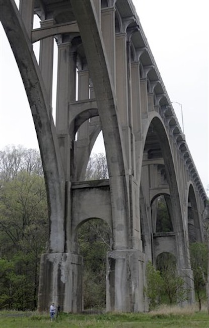 A cameraman stands beneath a bridge at the Cuyahoga Valley National Park in Brecksville, Ohio, on Tuesday, May 1, 2012. Five men have been arrested for conspiring to blow up the high level bridge over the Cuyahoga River valley, but there was no danger to the public because the explosives were inoperable and were controlled by an undercover FBI employee, the agency said Tuesday in announcing the men's arrests. (AP Photo/Amy Sancetta)