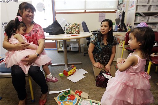 Angelina Sabuco, 2, sleeps in the arms of her aunt Marites Sabuco as her mom Ginady and twin sister Angelica look on at Lucile Packard Children's Hospital on Monday in Palo Alto, Calif.