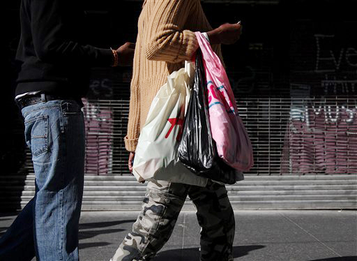 Shoppers carry their purchases along 33rd Street in New York recently. Americans' confidence in the economy in May had its biggest drop in eight months as consumers fretted about slow hiring, a big stock market drop and the global economy, according to the Conference Board, a private research group.