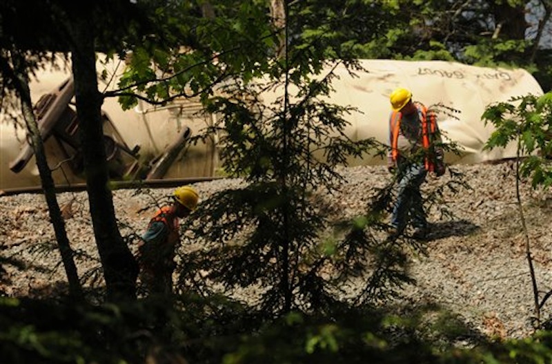 Pan-Am Railroad personnel work to repair the damaged rails on Saturday, May 26, 2012 near the Orrington-Bucksport town line after four tanker cars derailed on Friday sending two of the tankers into the Penobscot River. (AP Photo/Bangor Daily News, Kevin Bennett)
