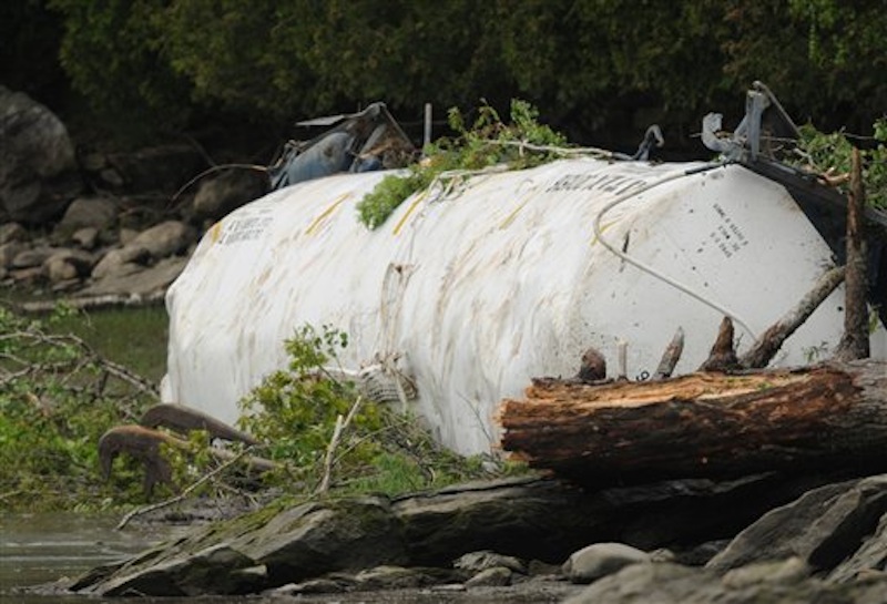 One of two tanker cars is seen along the shoreline of the Penobscot River on Saturday, May 26, 2012 near the Orrington -Bucksport town line after four tanker cars derailed on Friday sending two of the tankers over an embankment and into the Penobscot River. (AP Photo/Bangor Daily News, Kevin Bennett)