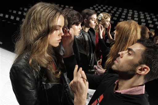 Models have their make-up finalized under runway light during Fashion Week in New York recently. The 19 editors of Vogue magazines around the world made a pact to project the image of healthy models.