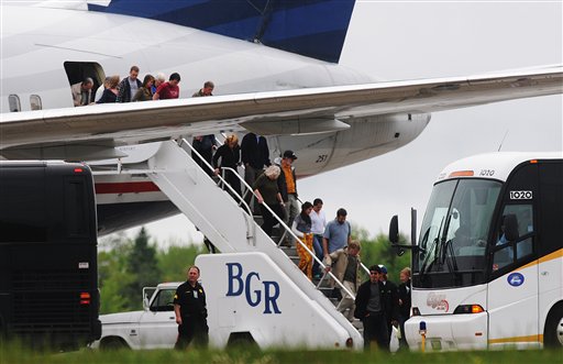 Passengers de-plane a trans-atlantic flight originating in France on the tarmac at Bangor International Airport, in Bangor, Maine, Tuesday, May 22, 2012. Officials briefed on the incident say a French passenger passed a note to a flight attendant saying she had a surgically implanted device. (AP Photo/Bangor Daily News, Kevin Bennett)