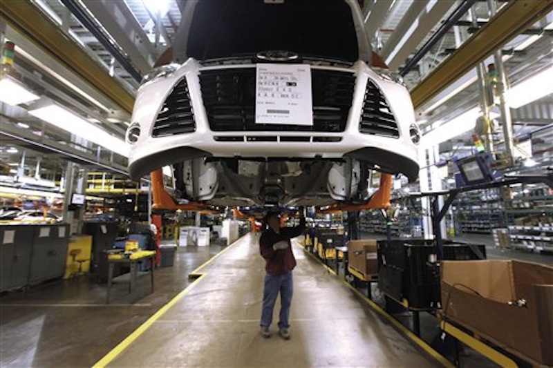 In this Dec. 14, 2011 file photo, a line worker assembles a 2012 Ford Focus at the Ford Michigan Assembly plant in Wayne, Mich. The plant is one 13 North American factories where Ford Motor Co. will be adding a a week of production in 2012, so the company can make another 40,000 vehicles this year and meet the needs of rising car and truck sales. (AP Photo/Paul Sancya, File)