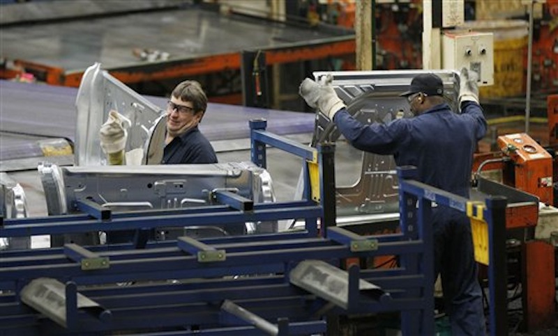 In this April 4, 2012 file photo, auto workers at the Ford Stamping Plant in Chicago Heights, Ill., stack the inner door panel for a Ford Explorer. On Tuesday, May 8, 2012, Ford said it will make 40,000 additional cars and trucks this year by cutting a week out of the normal summer shutdown at 13 factories. Auto plants normally close for two weeks around the July 4 holiday to switch production to the next model year. But Ford says the plants will close for only one week in order to keep up with rising demand for Ford vehicles. (AP Photo/Charles Rex Arbogast, File)
