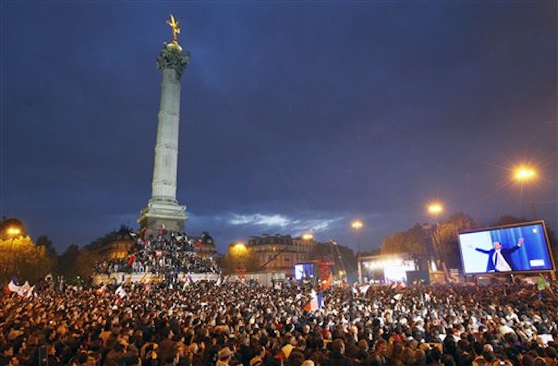 Supporters of Socialist President-elect Francois Hollande, seen on the video screen at right, celebrate after the results of the second round of the French Presidential elections were announced at Bastille square in Paris, France, Sunday, May 6, 2012. Hollande defeated outgoing President Nicolas Sarkozy on Sunday to become France's next president, Sarkozy conceded defeat minutes after the polls closed. (AP Photo/Francois Mori)