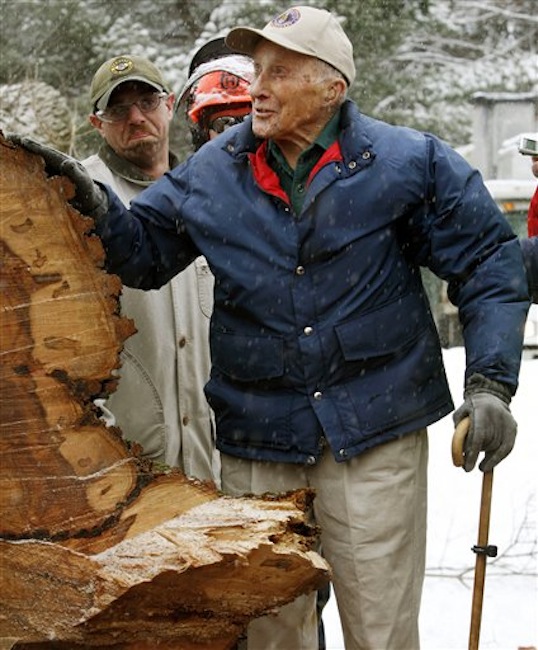 In this Jan. 19, 2010 file photo, Frank Knight puts his hand on New Englandís tallest elm tree, known as "Herbie," after it succumbed to Dutch elm disease and was cut down in Yarmouth, Maine. Knight, who took care of the tree for five decades while working as the Yarmouth tree warden, died in Scarborough, Maine, Monday, May 14, 2012. He was 103. (AP Photo/Pat Wellenbach, File)