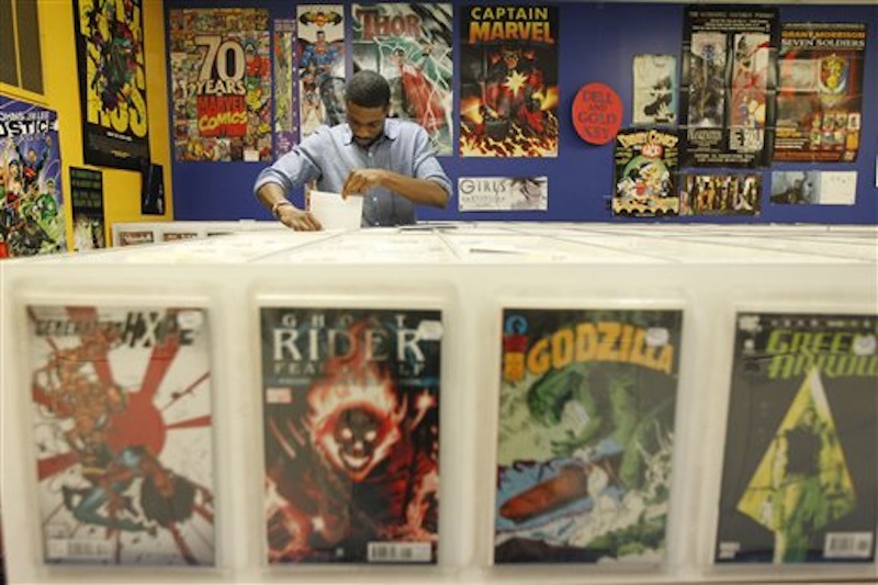 Ron Ackins, 29, of Philadelphia, checks out back issues of comics at Fat Jack's Comicrypt, Friday, May 4, 2012, in Philadelphia. Like hundreds of other comic specialty shops in 46 countries, the store is participating in Free Comic Book day on Saturday, May 5, which sees shops give away free copies of new and reprinted comics from some 40 publishers, including Marvel, DC, Archie, Image, Dark Horse, Valiant and Dynamite, among others, to promote the growth of the medium and garner new readers, some of whom may have been exposed to heroes through television and films. Free Comic Book day started 11 years and continues to expand, said Joe Field, who helped organize the inaugural event. This year, some 3.5 million free comics will be handed out. (AP Photo/Matt Rourke)