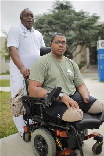 Larry Bailey, left, stands with his son Marine Cpl. Larry Bailey II of Zion, Ill., at Walter Reed National Military Medical Center in Bethesda, Md., last week. The 26-year-old Marine tripped a rooftop bomb in Afghanistan in June 2011. He ended up a triple amputee and expects to get a hand transplant this summer.