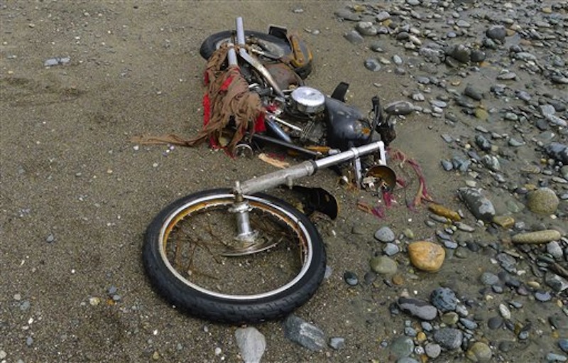 In this photo taken by Canadian Peter Mark in the end of April 2012, and released on Wednesday, May 2, a Harley-Davidson motorbike lies on a beach in Graham Island, western Canada. Japanese media say the motorcycle lost in last year's tsunami washed up on the island about 6,400 kilometers (4,000 miles) away. The rusted bike was originally found by Mark in a large white container where its owner, Ikuo Yokoyama, had kept it. The container was later washed away, leaving the motorbike half-buried in the sand. Yokoyama, who lost three members of his family in the March 11, 2011, tsunami, was located through the license plate number, Fuji TV reported Wednesday. (AP Photo/Kyodo News, Peter Mark)
