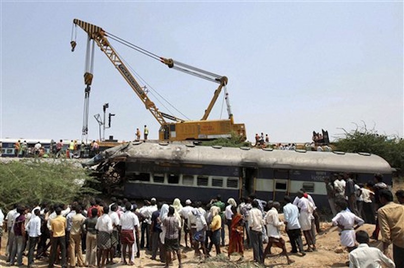 People watch rescue work at the scene of a train accident at a station near Penukonda, about 170 kilometers (105 miles) north of Bangalore, India, Tuesday, May 22, 2012. The passenger train rammed into a parked freight train and burst into flames before dawn Tuesday, killing more than a dozen people in southern India, officials said. (AP Photo)