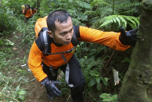 Indonesian rescuers walk through rugged terrain as they make their way to the site of a plane crash at Salak mountain in Cijeruk, Bogor, West Java, Indonesia, today. All on board were feared dead.