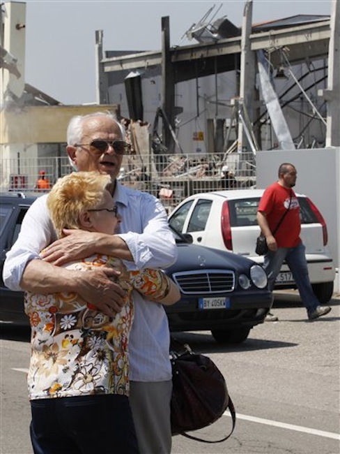 Mr. Borghi who lost his son in the building embraces his wife in front of the destroyed BBG industrial moldings in Mirandola, northern Italy, Tuesday, May 29, 2012. A magnitude 5.8 earthquake struck northern Italy on Tuesday, killing at least 10 people as factories, warehouses and a church collapsed in the same region still struggling to recover from another deadly tremor nine days ago. (AP Photo/Luca Bruno)