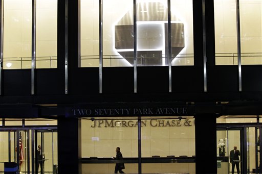 People walk inside the lobby of a JPMorgan Chase building in New York on Thursday. The company's stock plunged almost 7 percent in after-hours trading after the loss was announced. Other bank stocks, including Citigroup and Bank of America, suffered heavy losses as well.
