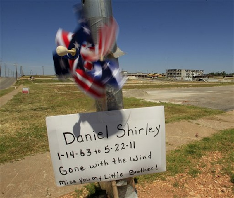 A sign remembering a tornado victim is seen on a street corner Tuesday, May 22, 2012, in Joplin, Mo. The community is marking the anniversary of an EF-5 tornado that killed 161 people as it cut a wide swath through Joplin a year ago. (AP Photo/Charlie Riedel)