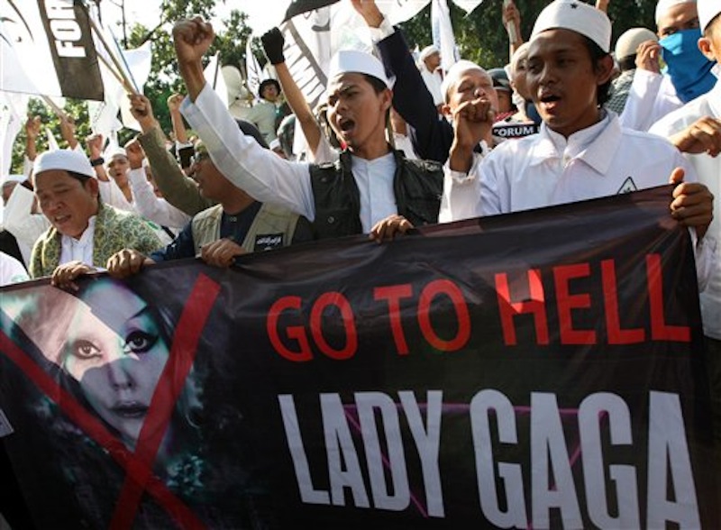Muslim men shout slogans during a rally against U.S. pop singer Lady Gaga's concert that is scheduled to be held on June 3, outside the U.S. Embassy in Jakarta, Indonesia, Friday, May 25, 2012. Lady Gaga might have to cancel her sold-out show in Indonesia because police worry her sexy clothes and dance moves undermine Islamic values and will corrupt the country's youth. (AP Photo/Dita Alangkara)