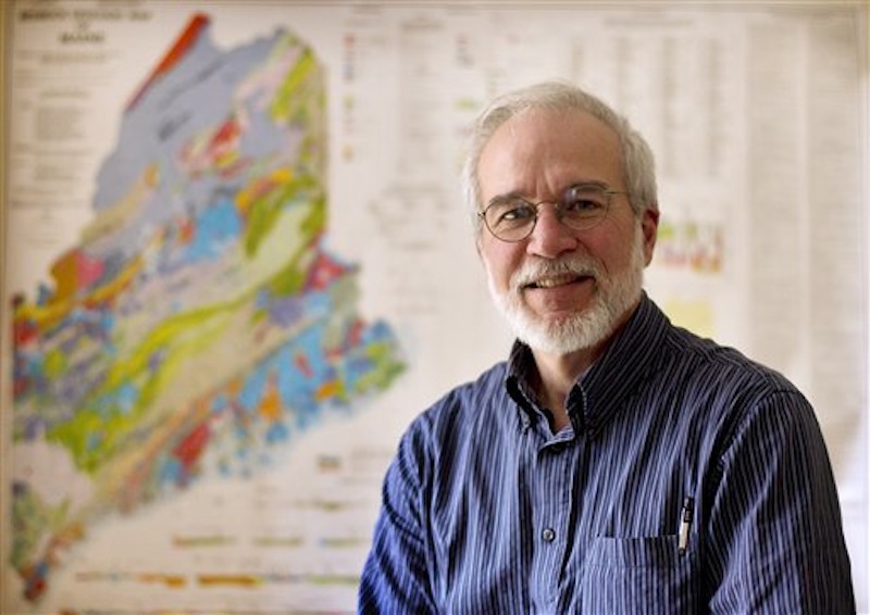In this photo made Thursday, April 26, 2012, Maine State Geologist Robert Marvinney stands in front of a map of the state's bedrock geologic map of Maine, in his office in Augusta, Maine. A bill was signed last week setting in motion an overhaul of 2-decades-old state mining regulations. (AP Photo/Robert F. Bukaty)