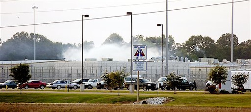 Smoke rises above the Adams County Correctional Center in Natchez, Miss., Sunday, May 20, 201, during an inmate disturbance at the prison. A guard at the southwest Mississippi prison died Sunday and several other employees were injured during what the facility's private operator is calling "an inmate disturbance" that continued into the evening. (AP Photos/The Natchez Democrat, Lauren Wood)