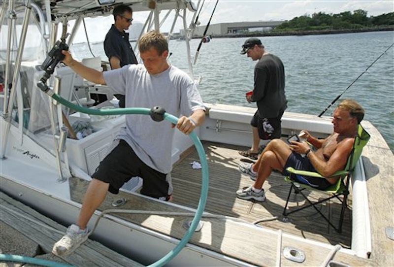 In this June 29, 2011 photo, fuel attendant Derek Locke, of Lynn, Mass., steps out of a sports fishing boat while fueling up on board as Ryan Chasse, of Lynn, opens his wallet to pay at the Seaport Landing Marina in Lynn, Mass. Much remains unknown about the region's hundreds of thousands of recreational boaters, even though they've been enjoying the chilly ocean waters as long as there have been people on land. Now, a massive survey aims to find out more about what these boaters do. (AP Photo/Charles Krupa)