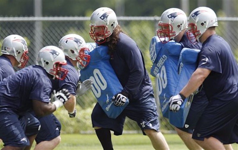 New England Patriots offensive lineman Robert Galley, center, holds a blocking pad while working out with teammates during an NFL football practice in Foxborough, Mass., Thursday, May 24, 2012. (AP Photo/Charles Krupa)