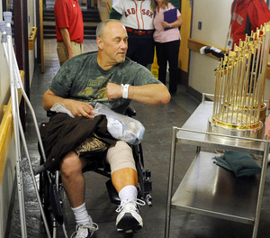 TROPHY ENCOUNTER: Mark Allen, of West Gardiner, brushes up against the Boston Red Sox 2004 and 2007 World Series trophies following knee surgery Wednesday at VA Maine Healthcare System-Togus. The Fenway Ambassadors visited patients and supporters of the health care facility for veterans.