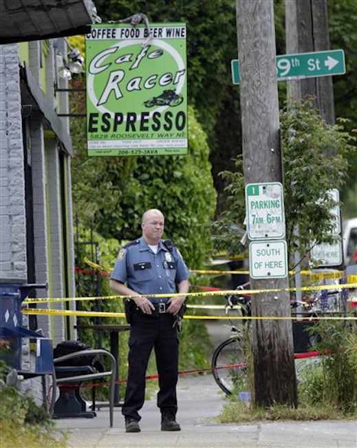 A Seattle Police officer stands outside a cafe where a shooting took place, Wednesday, May 30, 2012. A gunman opened fire at the cafe in Seattleís University district Wednesday, killing two people and critically wounding three others. Police are searching for the gunman, described as a man in his 30s wearing dark clothes. (AP Photo/Ted S. Warren)