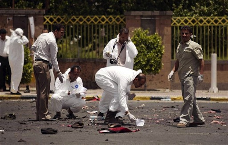 Forensic policemen collect evidence at the site of a suicide bomb attack at a parade square, killing some scores of people, in Sanaa, Yemen, Monday, May 21, 2012. Officials say Monday's bombing near Sanaa's presidential palace is one of the deadliest attacks in the city in months. (AP Photo/Hani Mohammed)